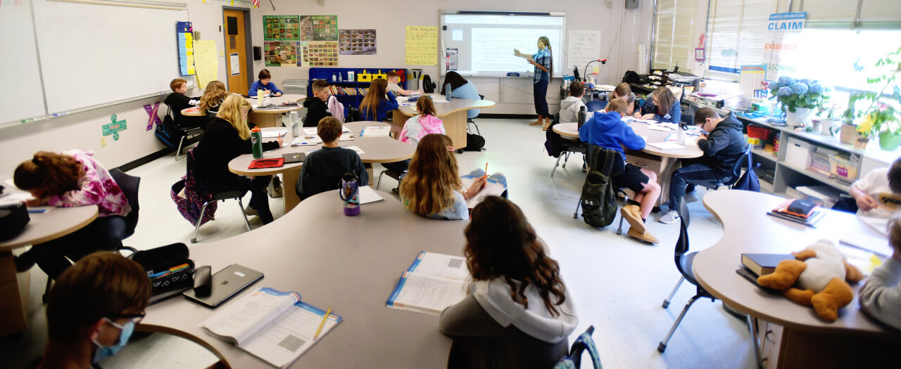 A teacher and students in a classroom setting.