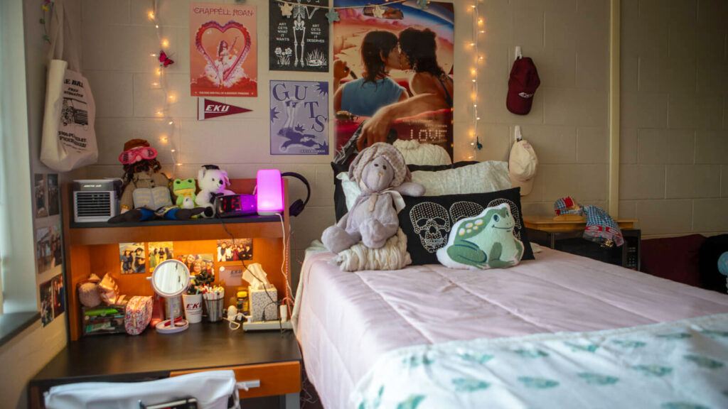 a bed in a Walters Hall bedroom between a desk and a microwave