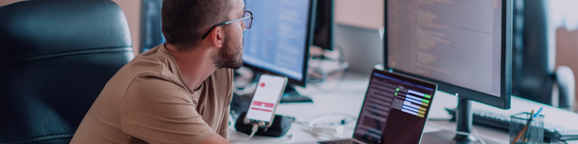 a programmer diligently testing smartphone applications while sitting in a computer