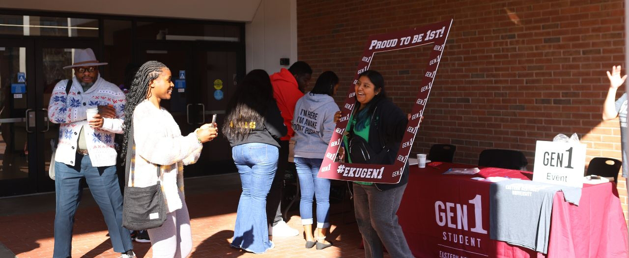 EKU student take photos with a giant EKU Gen 1 photo frame outside Powell at the First Generation College Celebration Day.