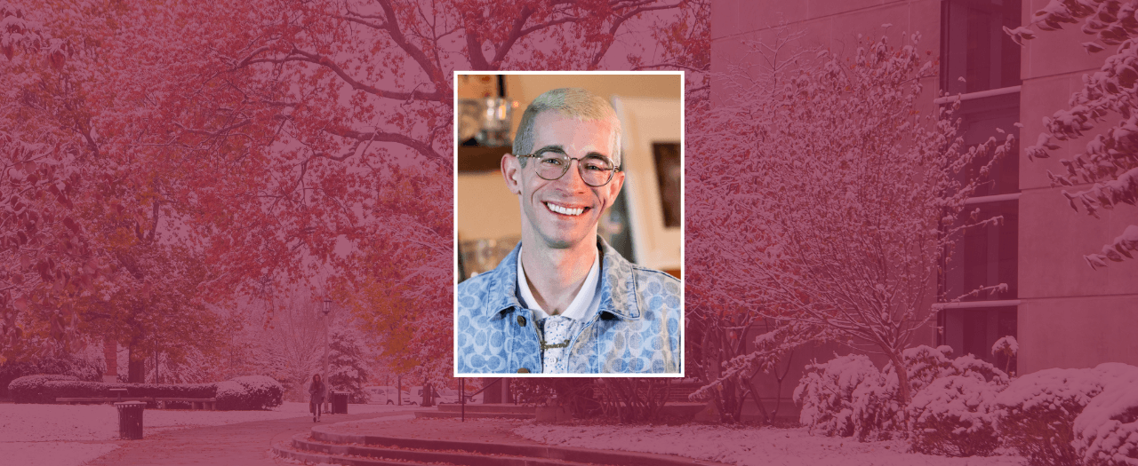 Photo of smiling man, Spencer Barrett, on a maroon background