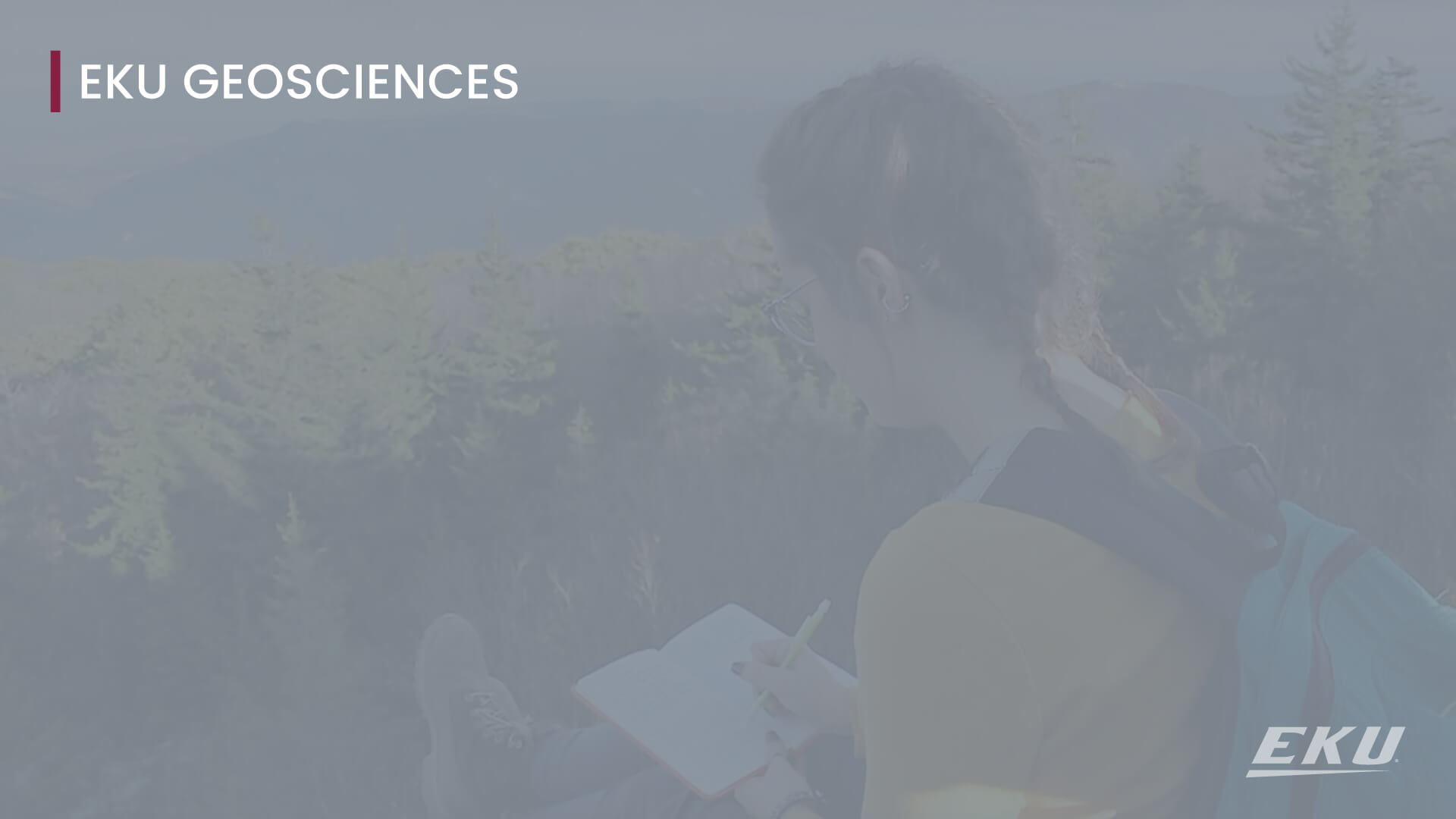 Text that says "EKU Geosciences" with an image of a student sitting close to a cliff overlooking a large forrest while she is writing in a notebook